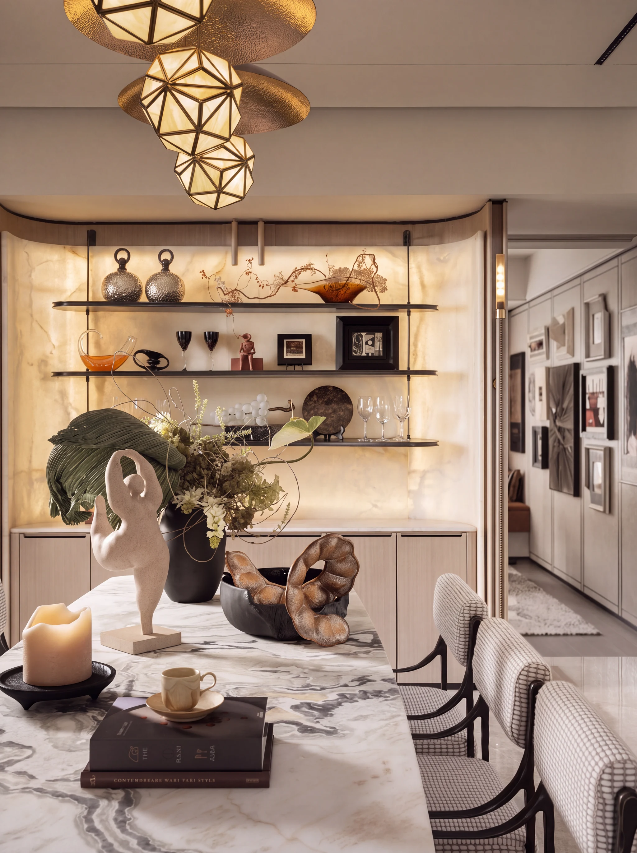 Dining under faceted brass pendants, with a gallery corridor beyond